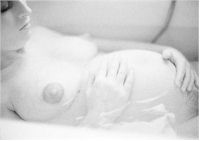 pregnant woman in bathtub watching her belly